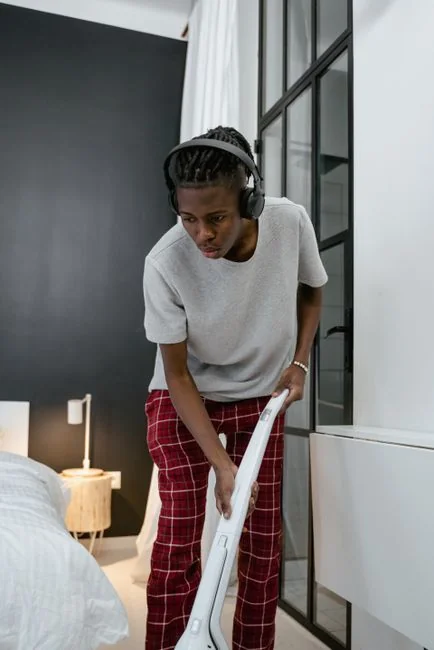 why-choose-us A woman is carefully covering a sofa with protective wrapping while packing boxes in a bright room.